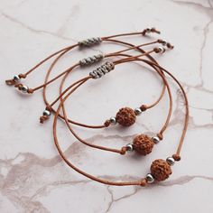 Handmade bracelet, crafted with care using a cotton brown cord, a sacred Rudraksha bead, and stainless steel beads. Embrace the powerful healing properties of Rudraksha, known for promoting tranquillity, clarity of mind, and positive energy. Elevate your spiritual journey and style with this unique and meaningful accessory, designed to bring harmony and balance to your life. 🚩 Bracelet is well-suited for both women and men, ensuring a comfortable fit for a wide range of wrist sizes, with a maxi Spiritual Brown Friendship Bracelets For Festivals, Spiritual Brown Beaded Bracelets With Adjustable Cord, Adjustable Brown Bracelet For Festivals, Adjustable Brown Bracelets For Festivals, Spiritual Brown Friendship Bracelets, Brown Spiritual Braided Bracelets For Friendship, Spiritual Brown Braided Friendship Bracelets, Spiritual Brown Friendship Bracelet With Sliding Knot, Brown Spiritual Bracelet With Sliding Knot