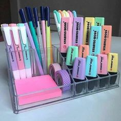 several different colored pens and pencils in a holder