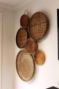 several woven baskets are hanging on the wall