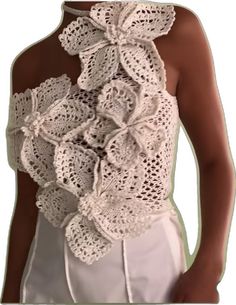 a woman wearing a white top with crocheted flowers on it's back