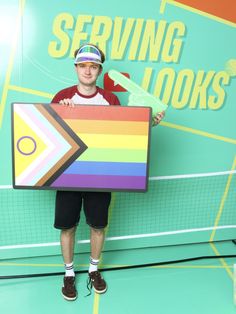 a man is holding up a large colorful sign