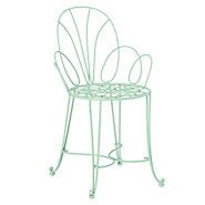 a green metal chair sitting on top of a white table