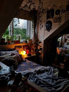 a bed sitting under a window next to a table with a lit candle on it