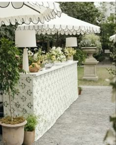 an outdoor bar with potted plants and lamps