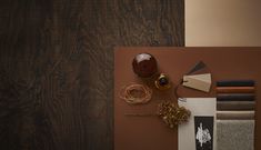 an assortment of materials are displayed on a brown table top with wood grained walls