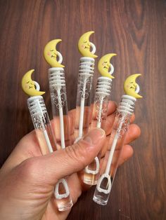 five plastic toothbrushes with smiley faces and crescent moon heads on them, sitting in front of a wooden table