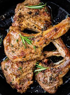 steaks in a skillet with rosemary garnish