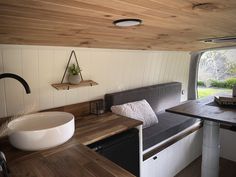 the interior of a tiny home with wood flooring and white walls, including a large round sink