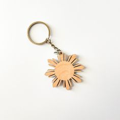 a wooden keychain with the shape of a sun on it's side