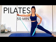 a woman is standing on a blue mat with a resistance band in front of her