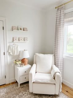 a white chair sitting next to a window in a living room