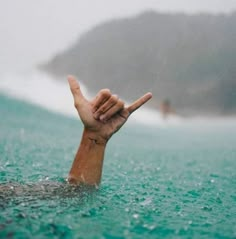 a person in the water holding their hand up