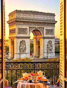 a table with food and drinks on it in front of the arc de trio triumph