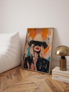 a painting is on the floor next to a lamp