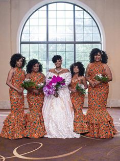 a bride and her bridal party posing for a photo in front of a large window