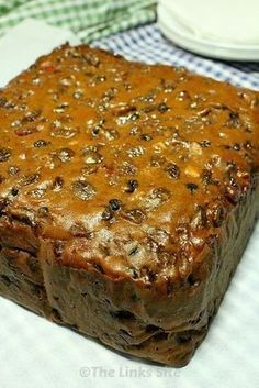 a close up of a square cake on a table with a plate in the background