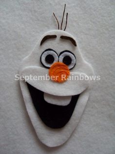 a close up of a face made out of felt with googly eyes and an orange nose