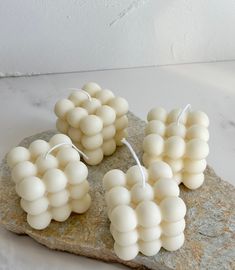 some white balls are on top of a rock and one is tied up with string