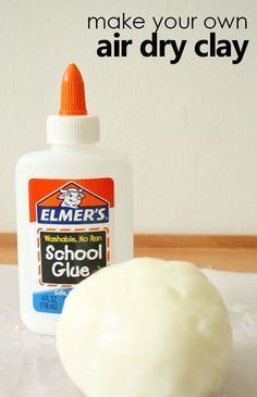 an orange and white object sitting on top of a table next to a bottle of glue