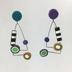 two pairs of earrings with different colored circles and shapes hanging from the ends of them