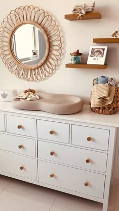 a white dresser topped with lots of drawers and a mirror on top of the dresser