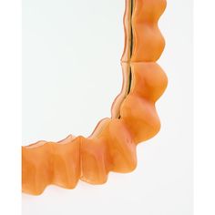 an orange tooth shaped object is shown against a white background and appears to be curved