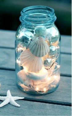 a mason jar filled with seashells and starfish