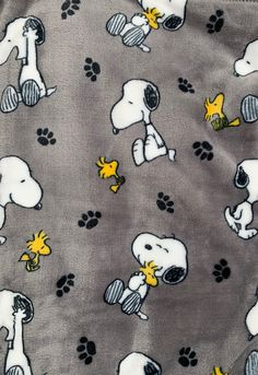 snoopy dogs on grey fabric with yellow and black paw prints, all over the surface