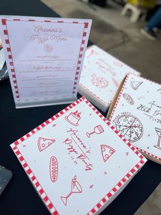 two pizza menus are on a table with red and white checkered napkins