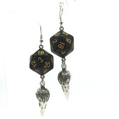 For Raven Queen worshippers who don't want to wear our huge and heavy (but very cool) raven earrings, we also offer this smaller, lighter (but still very cool) version. Each has a night-black D20. Beneath the dice hang silvery raven skull charms. These would be a perfect accessory for someone playing a member of the shadar-kai or a cleric that worships the Raven Queen. A great gift for players of D&D, Pathfinder, and other tabletop RPGs -- or for anyone who wants to geek out with a fun and myste Black Earrings For Halloween Festival, Nickel Free Black Plug Earrings For Festival, Black Pierced Earrings For Festival, Edgy Black Earrings For Festival, Black Fantasy Dangle Jewelry, Black Metal Fantasy Jewelry, Black Fantasy Style Pierced Earrings, Black Fantasy Earrings, Black Fantasy Style Earrings