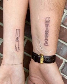 two people with matching tattoos on their arms