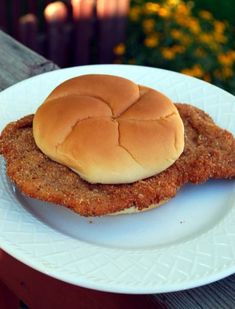 a chicken sandwich sitting on top of a white plate