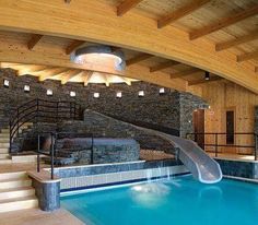 an indoor swimming pool with a slide in the middle and stairs leading up to it