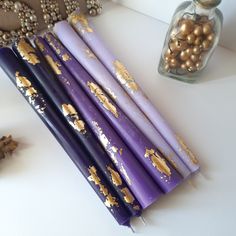 purple candles with gold sprinkles sitting on a table