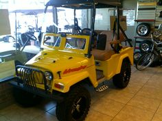 a yellow jeep parked inside of a building