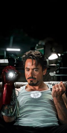 iron man lying in bed holding a light