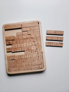 a wooden keyboard and four pieces of wood on a white surface with one piece missing