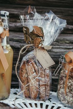 some cookies are sitting on a table next to two bottles and a basket full of nuts