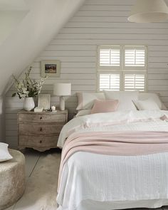 a bedroom with white walls and wooden furniture