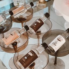 three glass trays with bottles on them sitting on top of a white marble counter