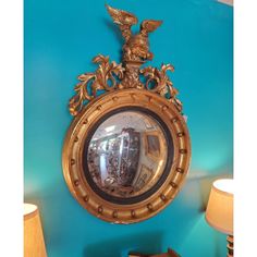 an ornate gold framed mirror on a blue wall