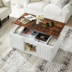 a living room with white couches and a coffee table on top of the rug