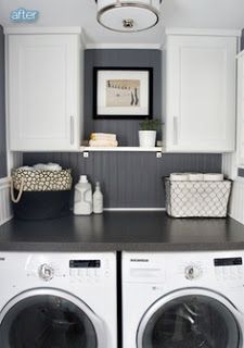 a washer and dryer in a laundry room with white cabinets, gray counter tops