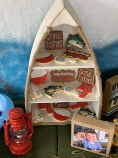 there is a boat shaped shelf with magnets on it and other items around it