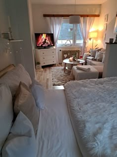 a bed room with a neatly made bed and a flat screen tv