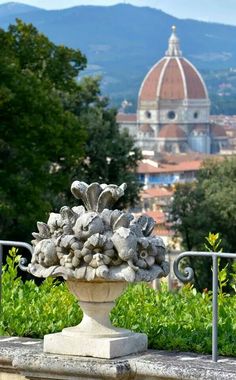 a stone vase with flowers in front of a building