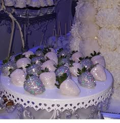 there are many strawberries on the table with white flowers in the background and decorations around it