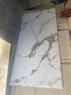 a large white marble slab sitting on top of a tile floor next to a wall