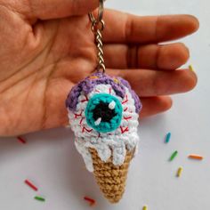 a crocheted ice cream cone keychain with an eyeball on it