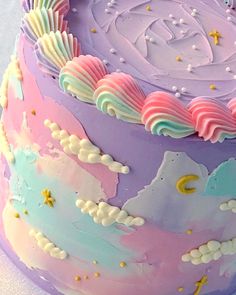 there is a cake that has been decorated with pastel colors and stars on it